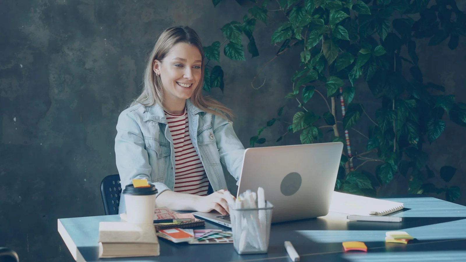 Smiling woman on a video call at a laptop in a bright office