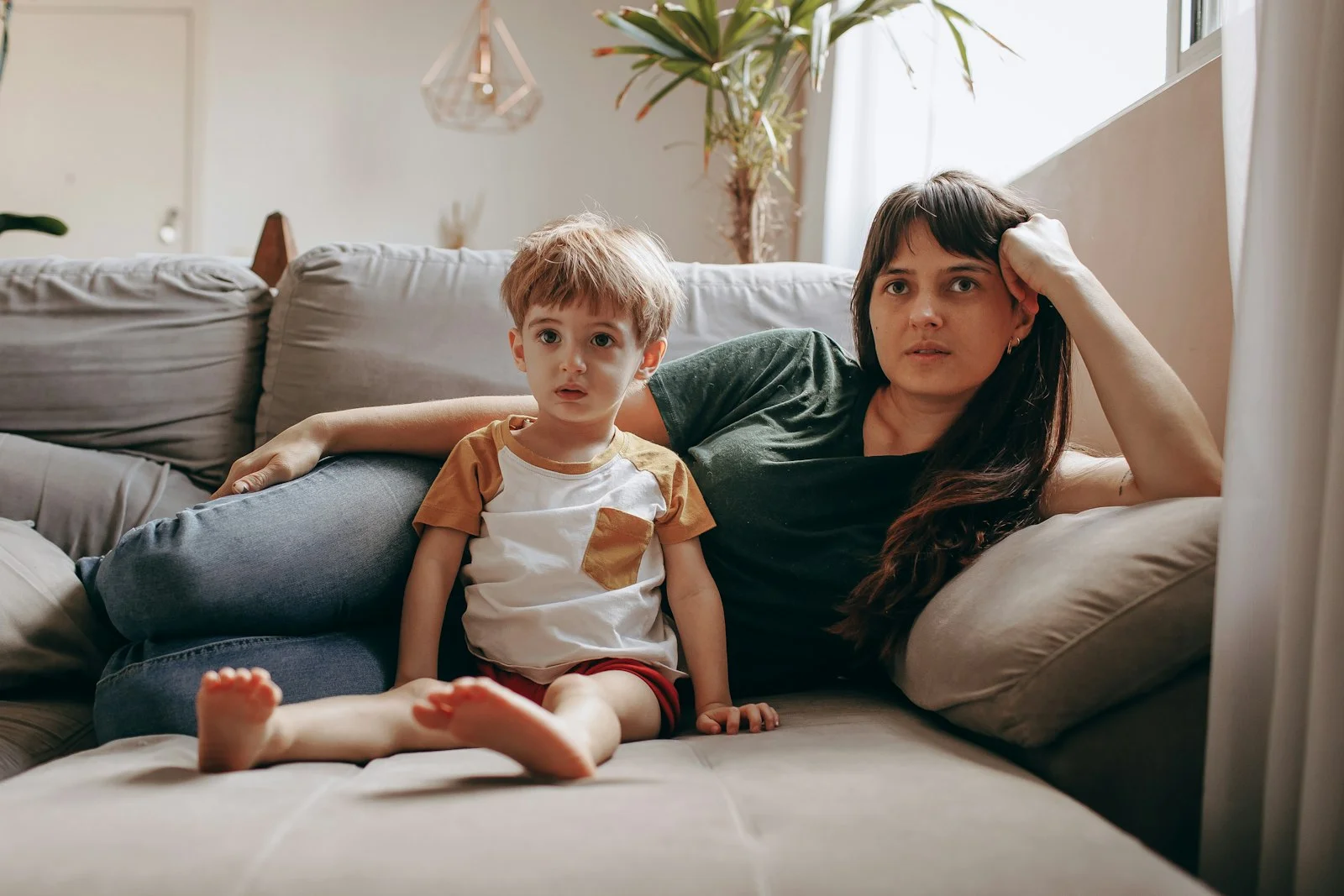 Woman and a young child sitting together on a couch