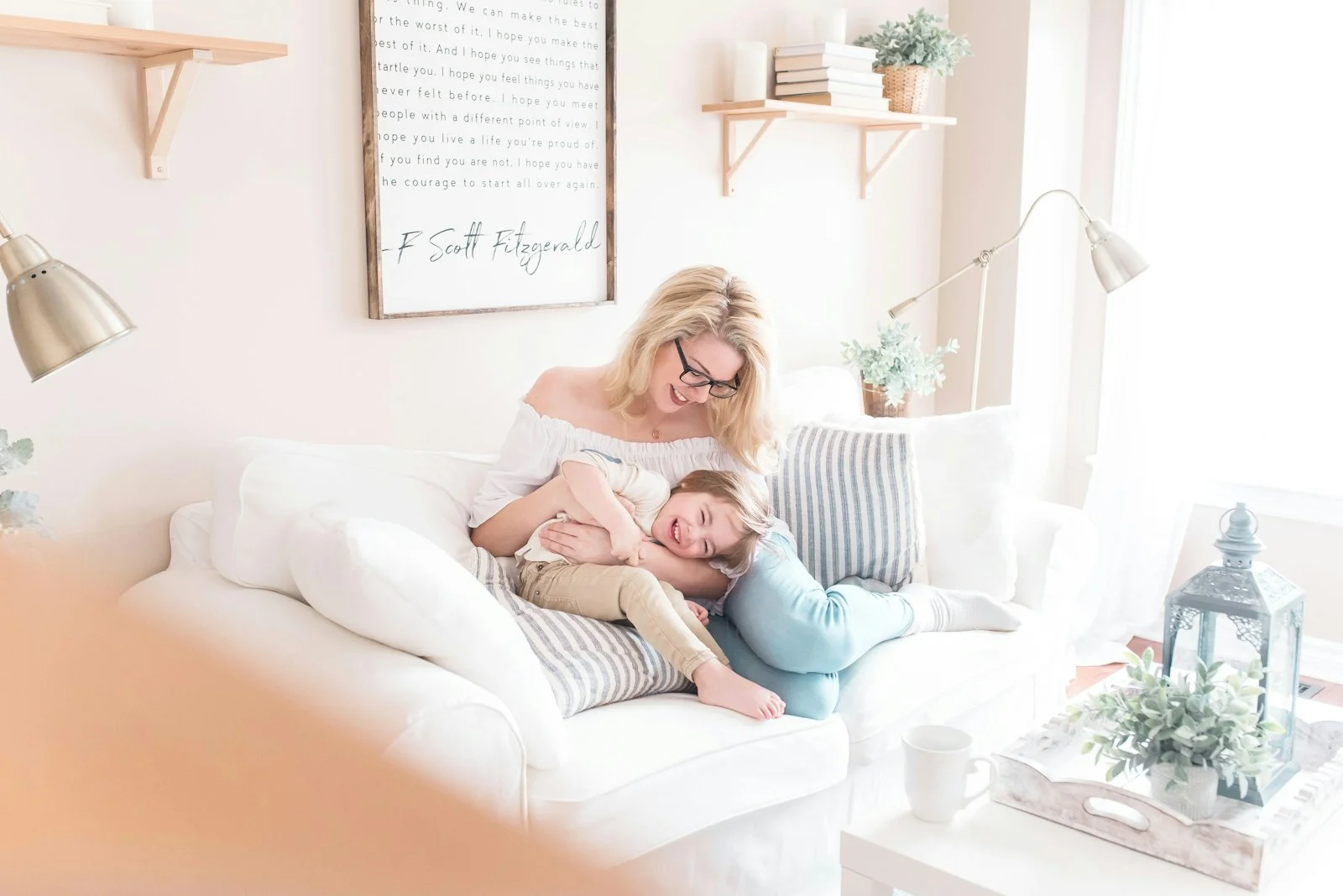 Woman and baby sitting together on a white sofa