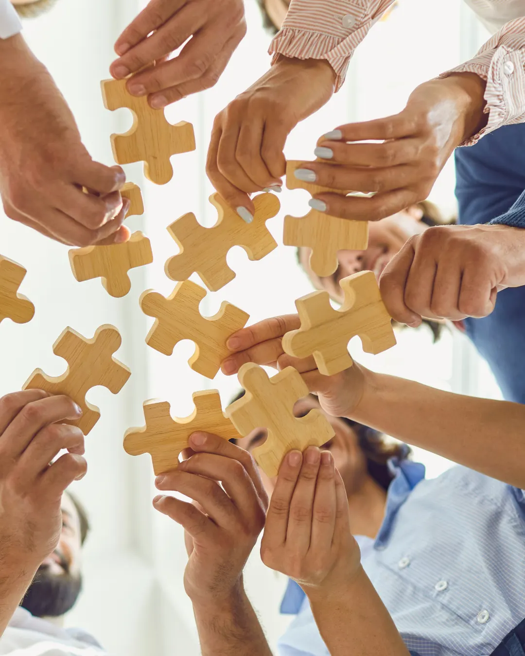 A team bringing wooden puzzle pieces together
