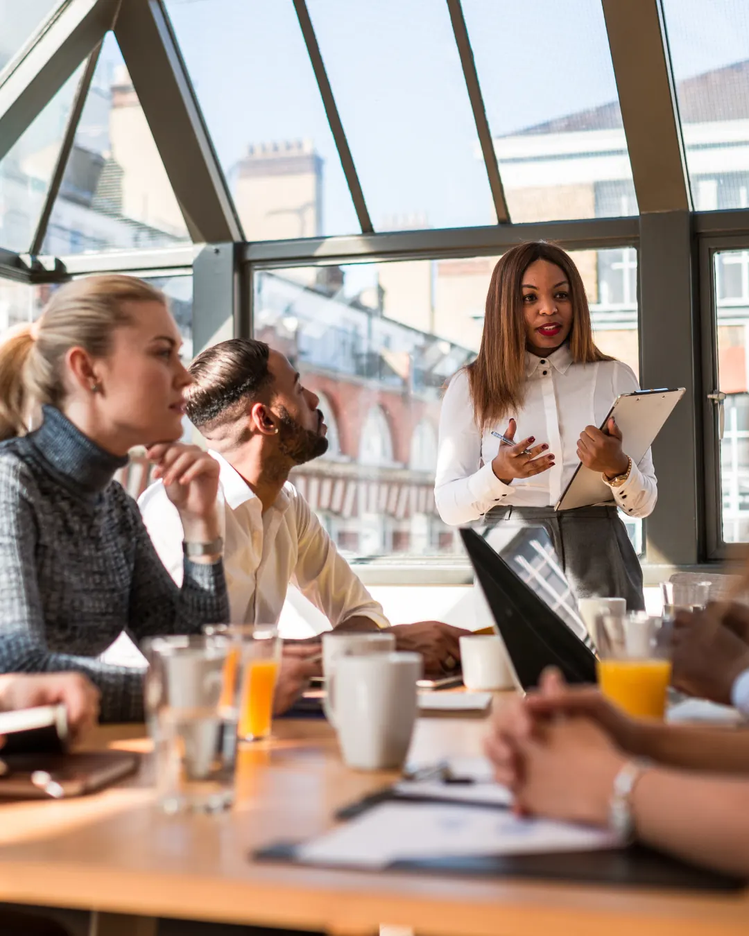 A facilitator leading a workshop with colleagues around a table